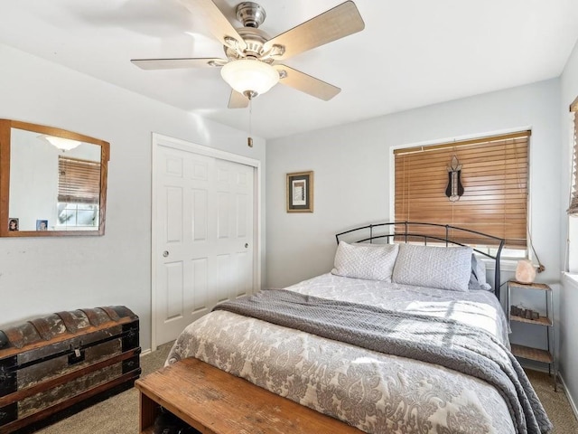 carpeted bedroom featuring ceiling fan and a closet