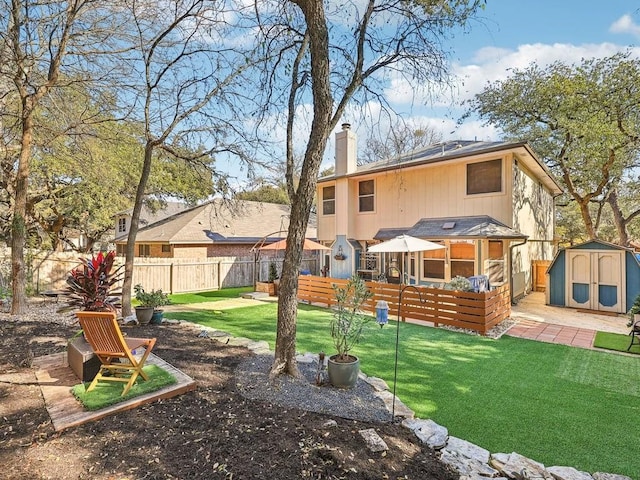 rear view of property featuring a storage shed and a yard