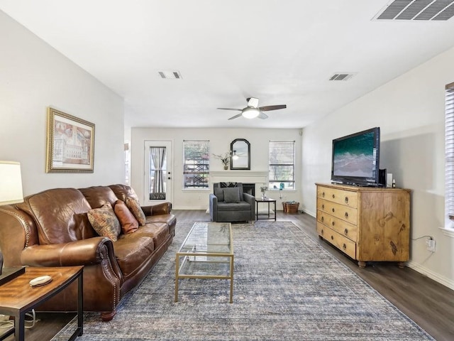 living room featuring ceiling fan and dark hardwood / wood-style floors