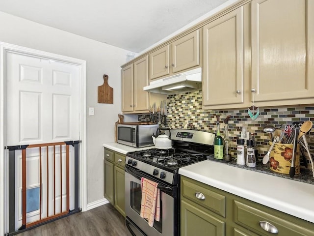 kitchen with appliances with stainless steel finishes, dark hardwood / wood-style flooring, and backsplash