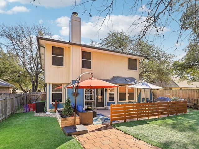 rear view of house with a yard and a patio area