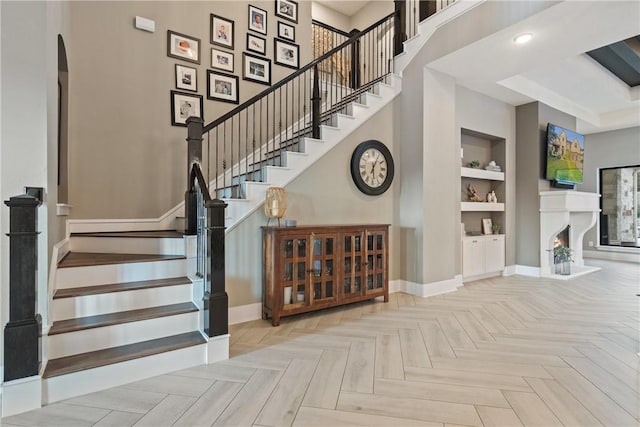 staircase featuring built in shelves and parquet floors