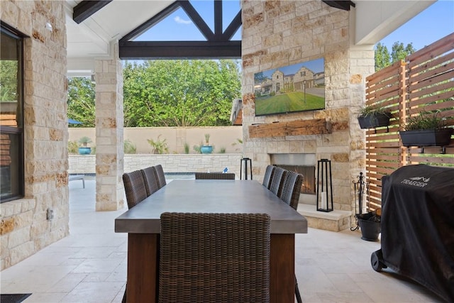 view of patio with grilling area and an outdoor stone fireplace