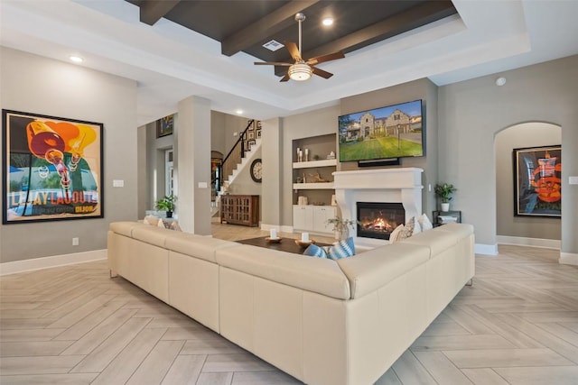 107 Bisset Ct, Austin, TX 78738 - living area with a tray ceiling, baseboards, and a glass covered fireplace