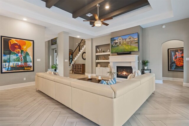 107 Bisset Ct, Austin, TX 78738 - living area featuring a glass covered fireplace, a raised ceiling, built in features, ceiling fan, and recessed lighting