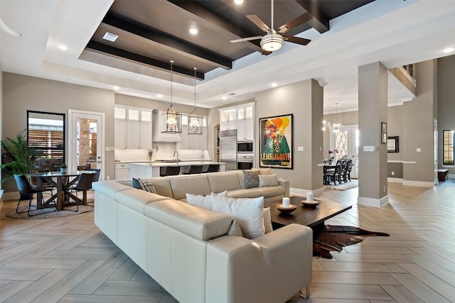 107 Bisset Ct, Austin, TX 78738 - living room with a tray ceiling, ceiling fan, a chandelier, and recessed lighting