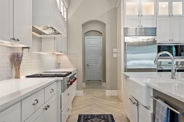 107 Bisset Ct, Austin, TX 78738 - kitchen featuring built in appliances, backsplash, and white cabinetry