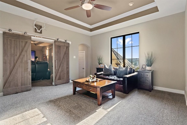 107 Bisset Ct, Austin, TX 78738 - carpeted living area featuring a barn door, a ceiling fan, arched walkways, and a raised ceiling