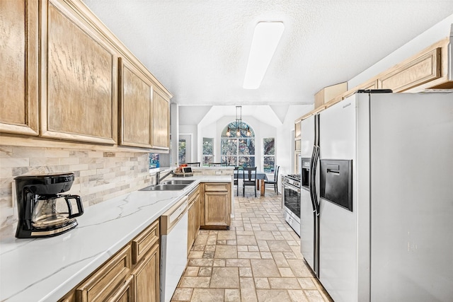 kitchen with stainless steel gas range, vaulted ceiling, white dishwasher, refrigerator with ice dispenser, and pendant lighting