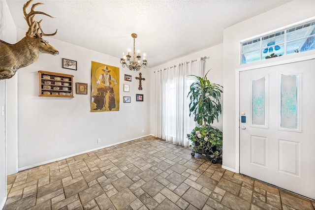 foyer entrance with a notable chandelier and a textured ceiling