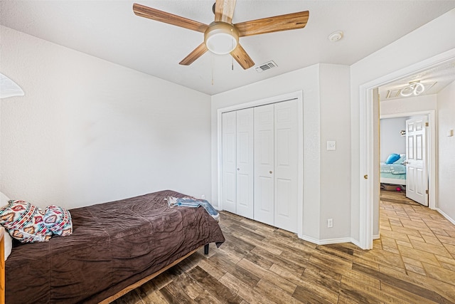 bedroom with wood-type flooring, a closet, and ceiling fan