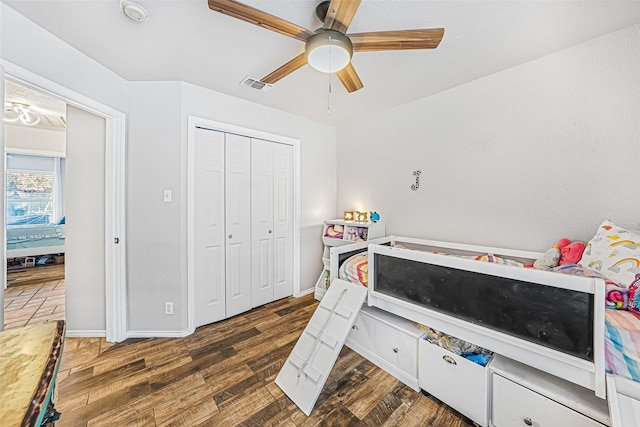 bedroom with dark hardwood / wood-style flooring, ceiling fan, and a closet