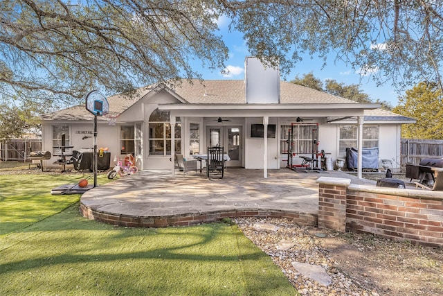 rear view of house with ceiling fan, a yard, and a patio area