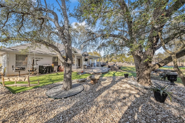 rear view of house featuring a lawn and a patio