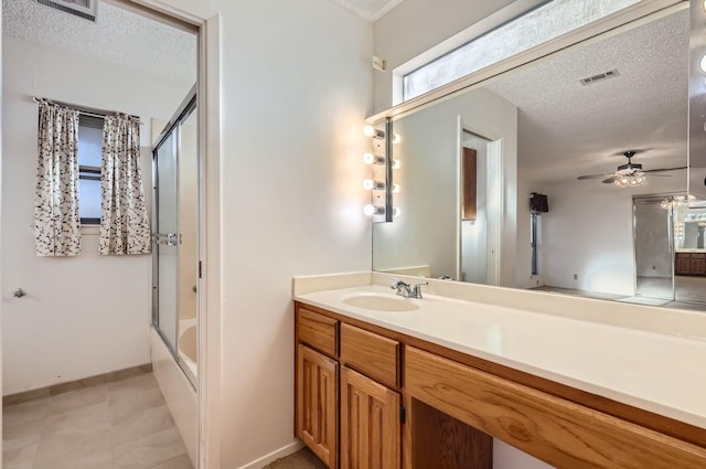 bathroom with vanity, ceiling fan, bath / shower combo with glass door, and a textured ceiling