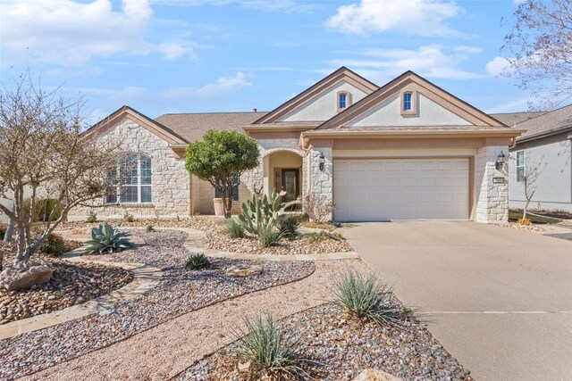 215 Goose Island Dr, Georgetown, TX 78633 - view of front facade featuring stone siding, driveway, an attached garage, and stucco siding