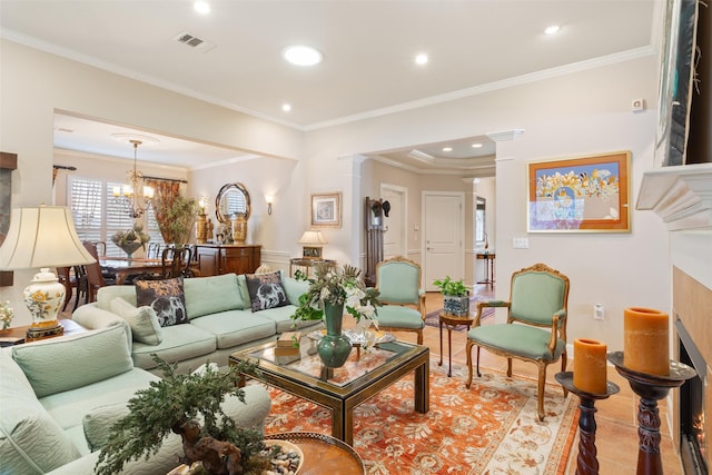 living room featuring a notable chandelier, ornamental molding, and decorative columns