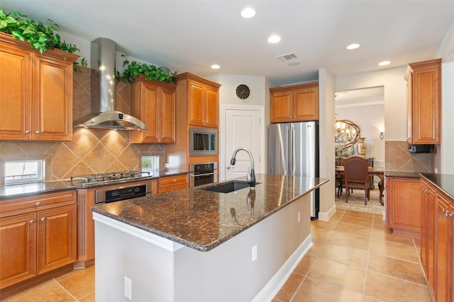 215 Goose Island Dr, Georgetown, TX 78633 - kitchen with wall chimney range hood, a sink, stainless steel appliances, brown cabinets, and dark stone counters