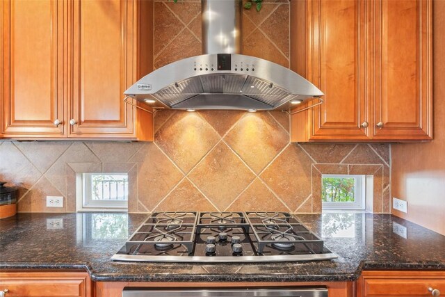 215 Goose Island Dr, Georgetown, TX 78633 - kitchen with wall chimney range hood, stainless steel gas stovetop, tasteful backsplash, and brown cabinets