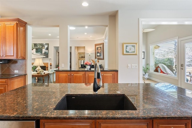 215 Goose Island Dr, Georgetown, TX 78633 - kitchen with a sink, dark stone countertops, tasteful backsplash, brown cabinetry, and recessed lighting
