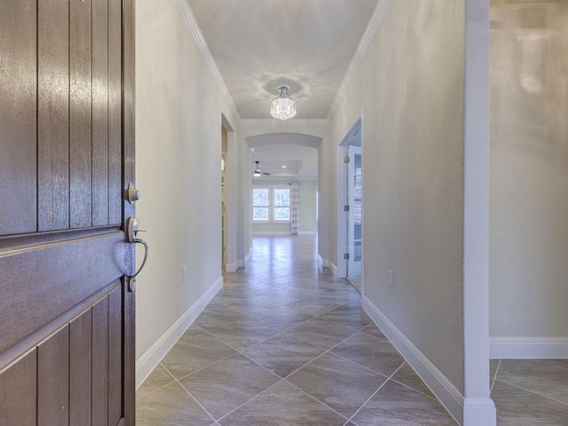 tiled entryway with ornamental molding and ceiling fan