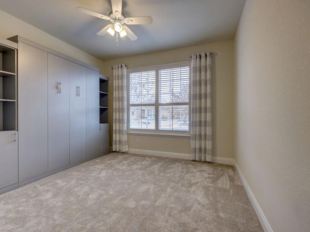 unfurnished bedroom featuring light colored carpet, a closet, and ceiling fan