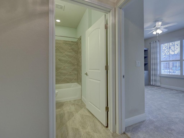 bathroom with tiled shower / bath combo and ceiling fan