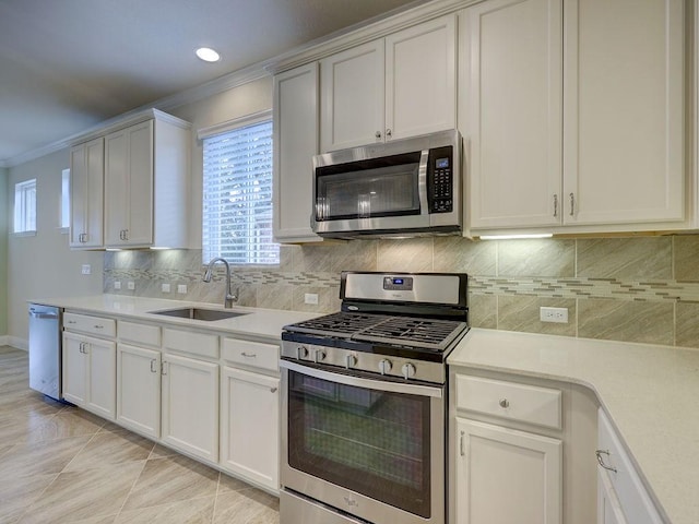 kitchen with sink, crown molding, light tile patterned floors, appliances with stainless steel finishes, and white cabinets