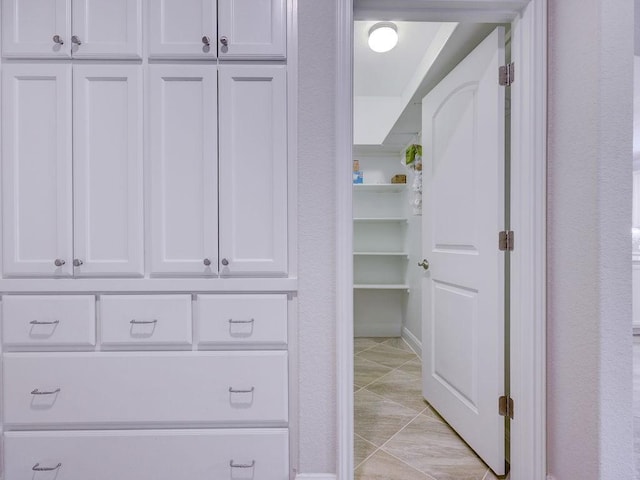 spacious closet with light tile patterned floors