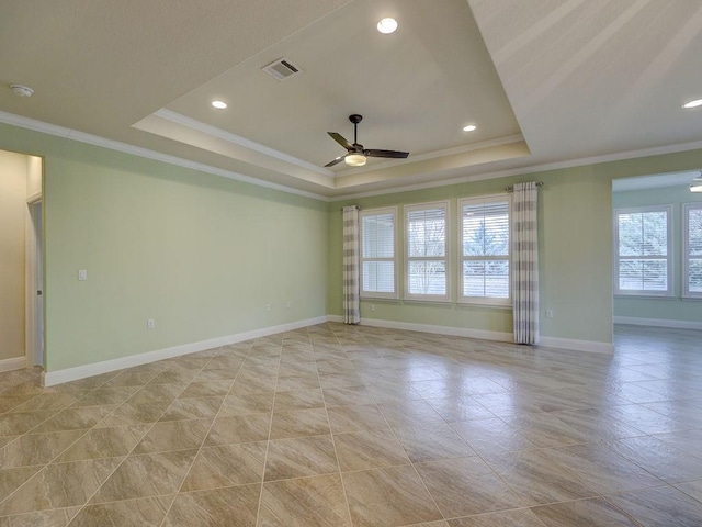 empty room with ceiling fan, ornamental molding, and a raised ceiling