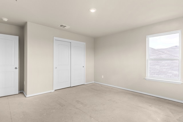 unfurnished bedroom with multiple windows and a closet