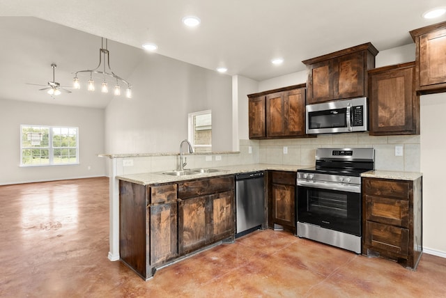 kitchen with sink, light stone counters, vaulted ceiling, hanging light fixtures, and appliances with stainless steel finishes