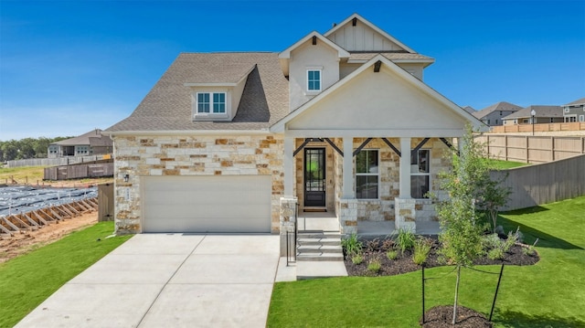 143 Big Pine Creek Ln, Bastrop, TX 78602 - view of front facade with stone siding, a porch, driveway, a shingled roof, and a garage