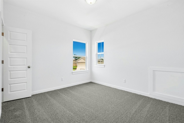 143 Big Pine Creek Ln, Bastrop, TX 78602 - empty room featuring dark colored carpet and baseboards