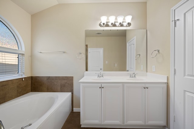 bathroom with lofted ceiling, vanity, and a tub