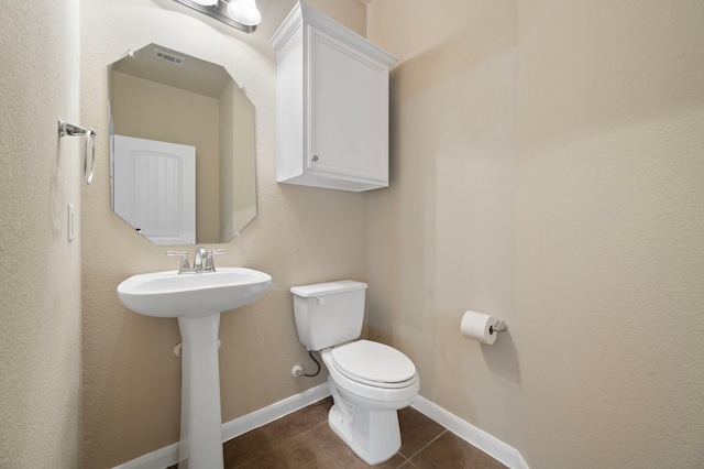 bathroom featuring sink, toilet, and tile patterned flooring