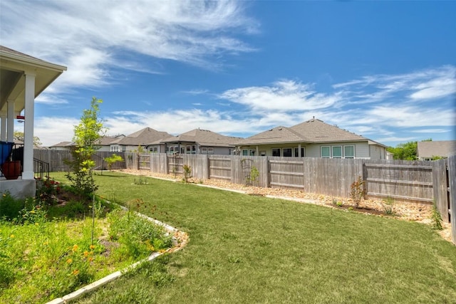 view of yard featuring a fenced backyard and a residential view