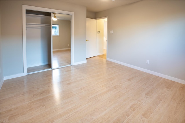 unfurnished bedroom with light wood-type flooring and a closet