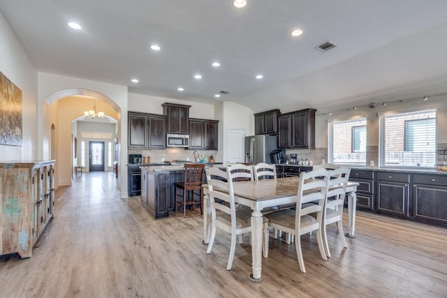 dining space featuring an inviting chandelier, plenty of natural light, and light hardwood / wood-style floors