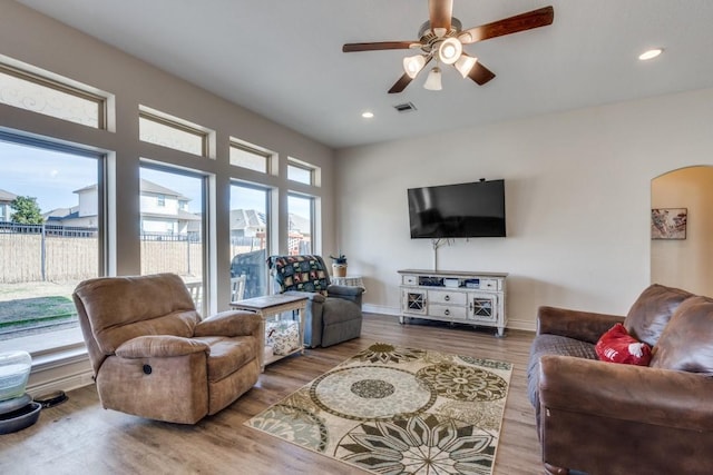 living room featuring hardwood / wood-style flooring, ceiling fan, and a wealth of natural light