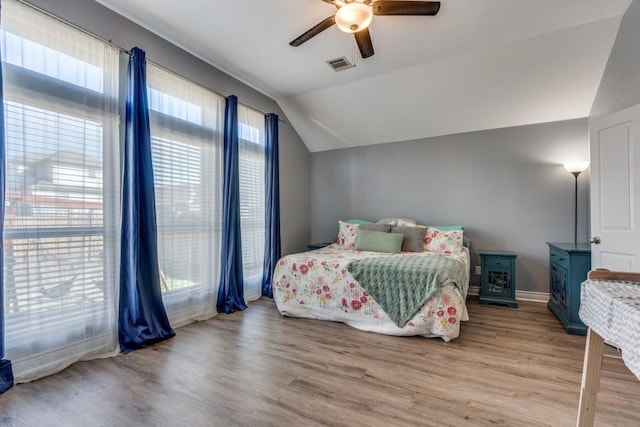 bedroom featuring hardwood / wood-style floors, vaulted ceiling, and ceiling fan