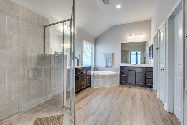 bathroom with vanity, vaulted ceiling, plus walk in shower, and wood-type flooring