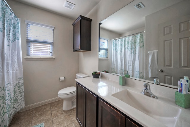 bathroom featuring tile patterned floors, a healthy amount of sunlight, toilet, and vanity