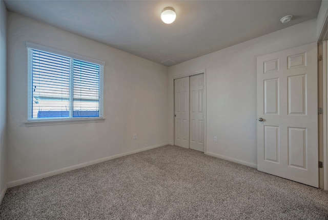 unfurnished bedroom with a closet and carpet flooring