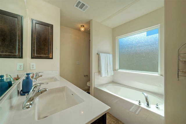 bathroom with tile patterned floors, toilet, a bathing tub, and vanity