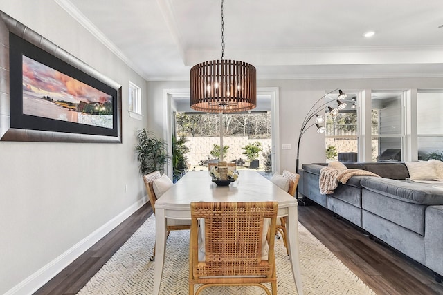 dining space featuring crown molding, an inviting chandelier, and hardwood / wood-style floors