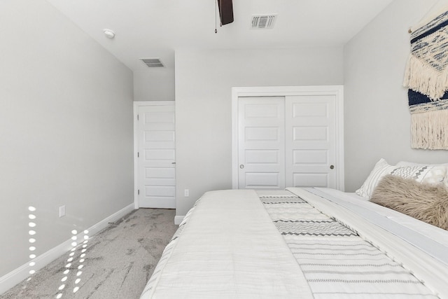 bedroom featuring ceiling fan, light carpet, and a closet