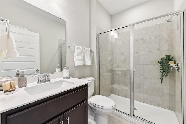 bathroom with vanity, toilet, and a shower with door