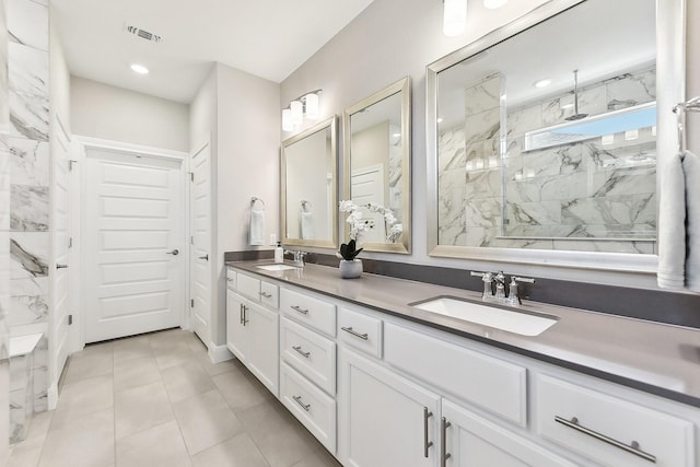 bathroom with vanity, tile patterned flooring, and a tile shower