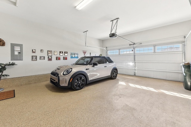 garage with a garage door opener and electric panel